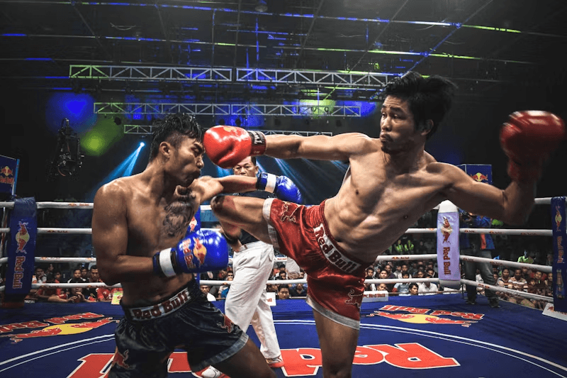 Muay Thai fighter turning a roundhouse through into a high guard — the visible turn Form Fighter can watch on camera.